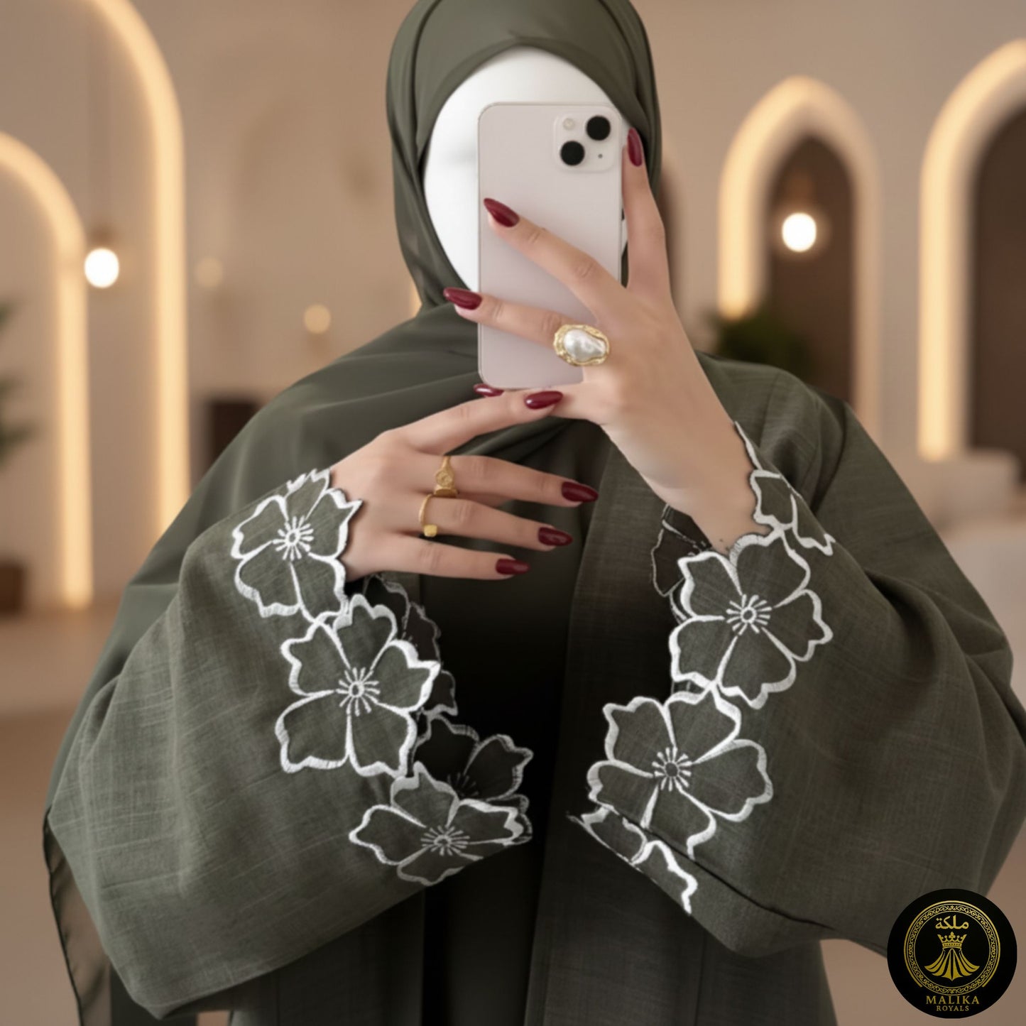 Person wearing a green abaya with floral embroidery