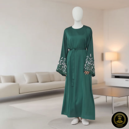 Mannequin wearing a green dress with floral sleeves in a modern living room setting.