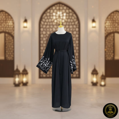 Black dress with white embroidery on a mannequin against an architectural background